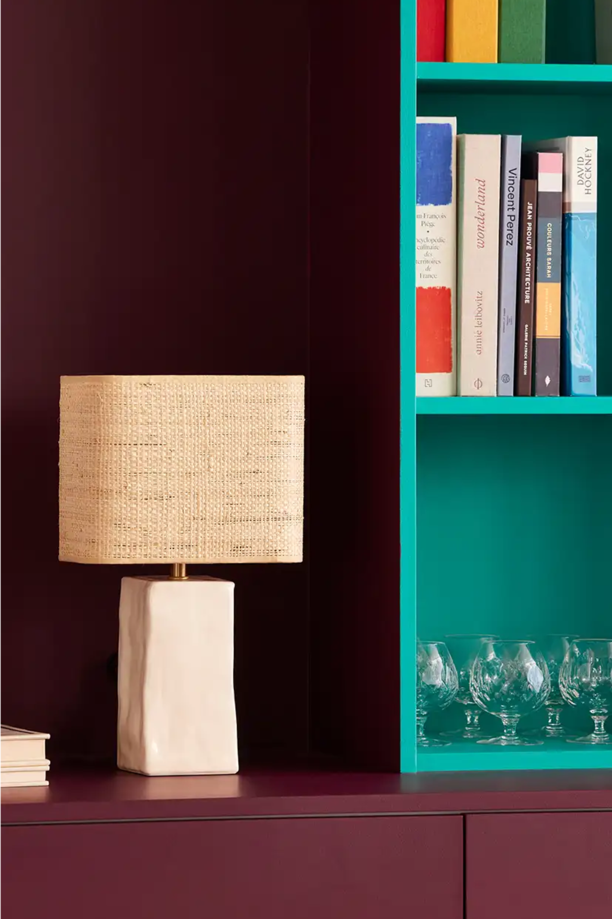 Sfeervol interieur met keramieken tafellamp en kleurrijke boekenkast