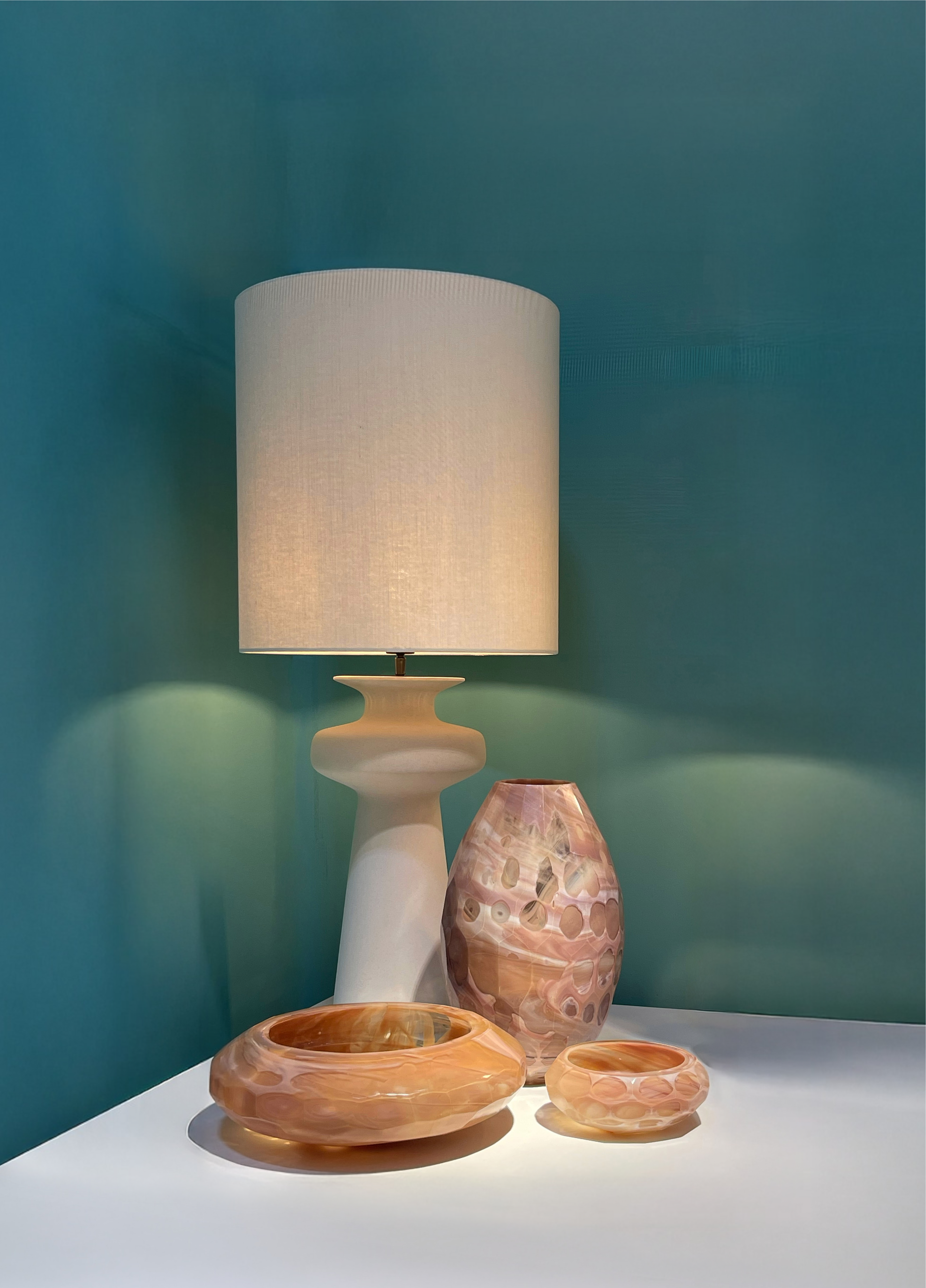 Sfeervol interieurbeeld met tafellamp en glazen objecten in warme tinten